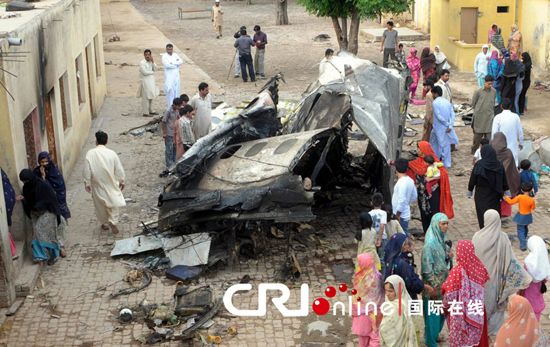 当地时间2012年4月22日,巴基斯坦民众来到客机坠毁现场悼念遇难者(国际在线/CFP)